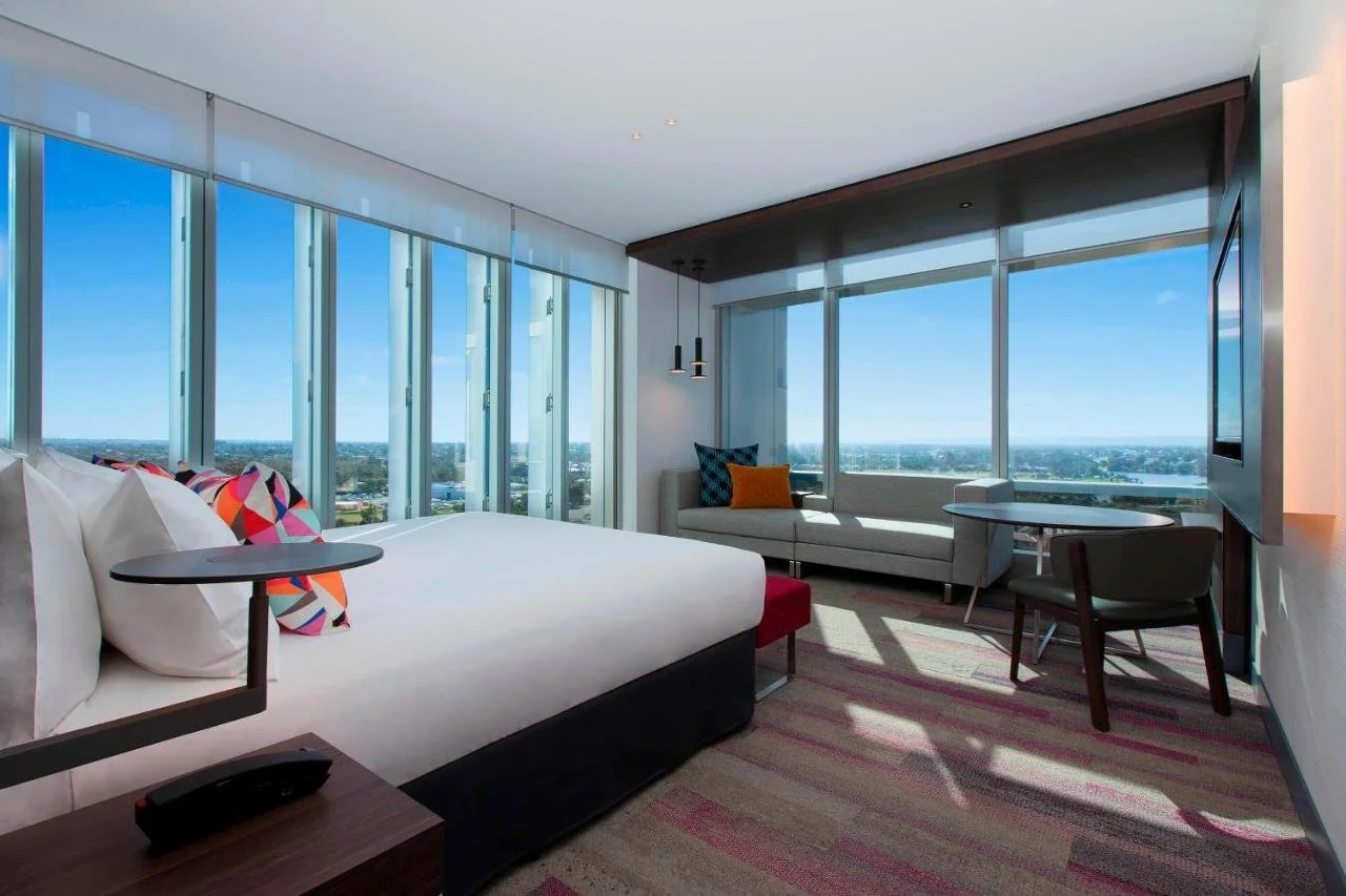 Aloft Perth Rivervale upper-floor room with floor-to-ceiling windows and Swan River and suburban Perth views