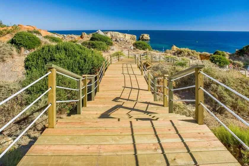 Kimpton Atlantico Algarve Albufeira wooden cliff pathway descending through scrubland to São Rafael Beach and Atlantic Ocean