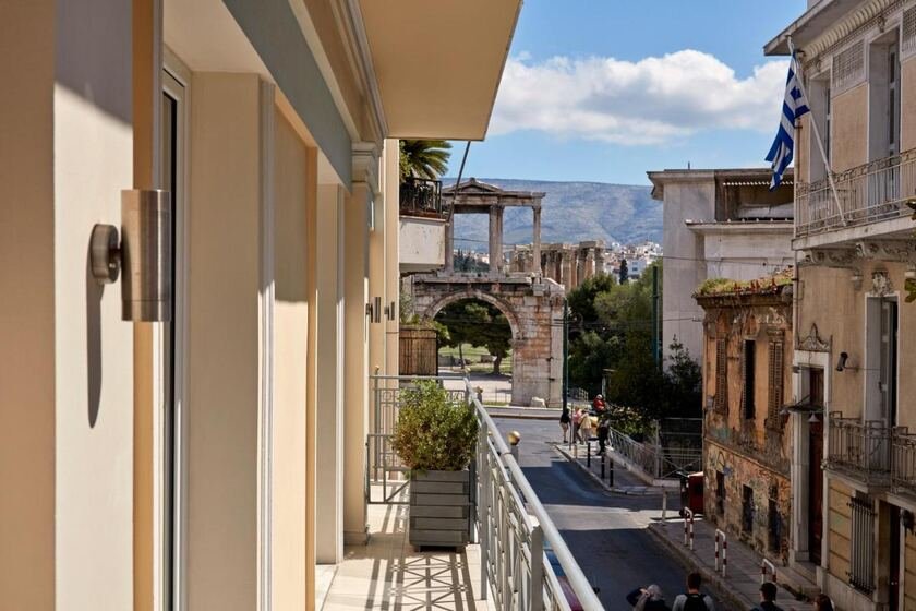 AVA Hotel & Suites Athens balcony view of Hadrian's Arch and Plaka street with Hymettus mountain in background
