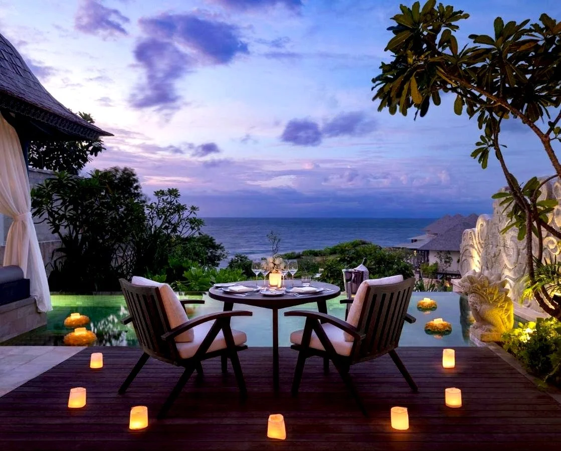 Jumeirah Bali Uluwatu private villa terrace candlelit dinner setup at dusk with infinity pool and Indian Ocean view