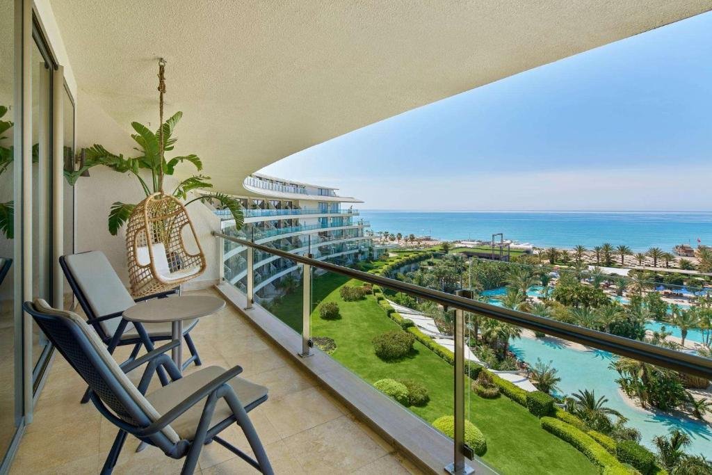 Maxx Royal Belek Golf Resort Antalya balcony overlooking resort pools, palm gardens and Mediterranean coastline