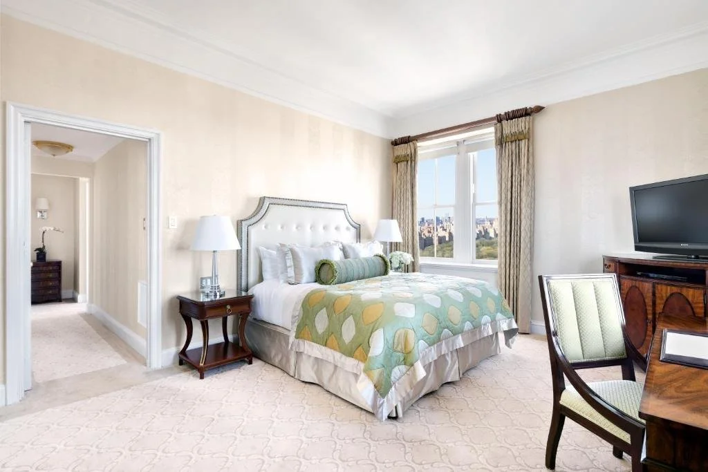 The Pierre Taj Hotel New York Upper East Side bedroom with Central Park treetops and Upper West Side skyline through window