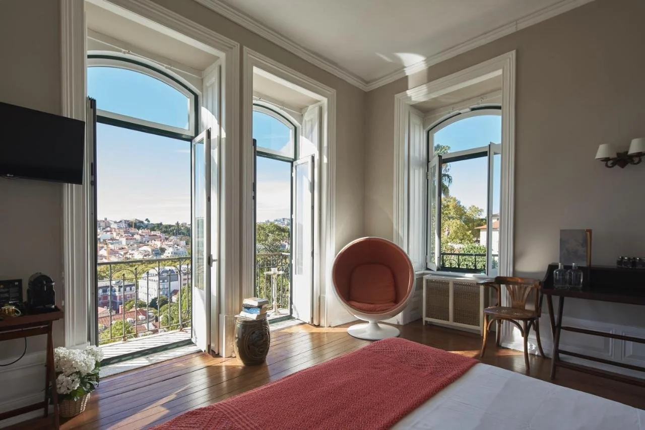 Torel Palace Lisbon suite with multiple arched balcony doors overlooking Lisbon historic rooftops and castle hill