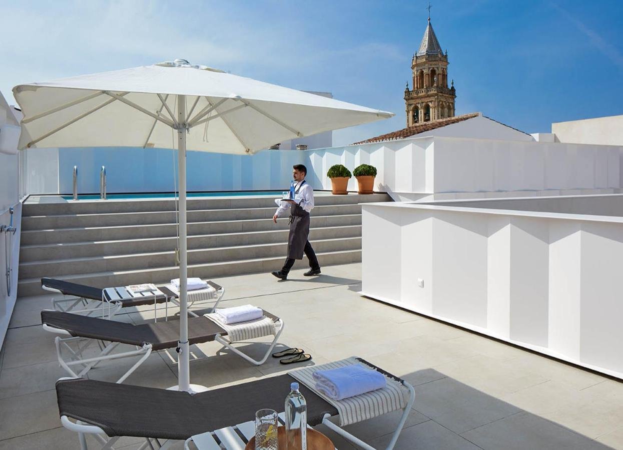 Hotel Posada del Lucero Seville rooftop terrace with sun loungers and Parroquia de San Pedro Apóstol tower