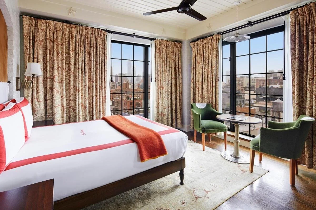 The Bowery Hotel New York East Village room with steel-frame windows overlooking neighborhood rooftops and water towers