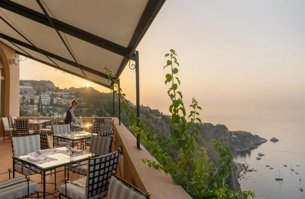 San Domenico Palace Taormina clifftop restaurant terrace overlooking the Ionian Sea at sunset