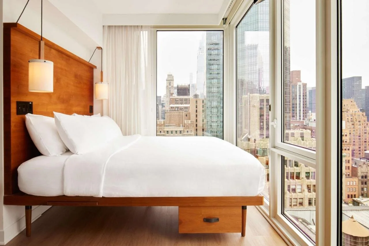 Arlo NoMad New York hotel room with Midtown skyline and Chrysler Building through floor-to-ceiling windows