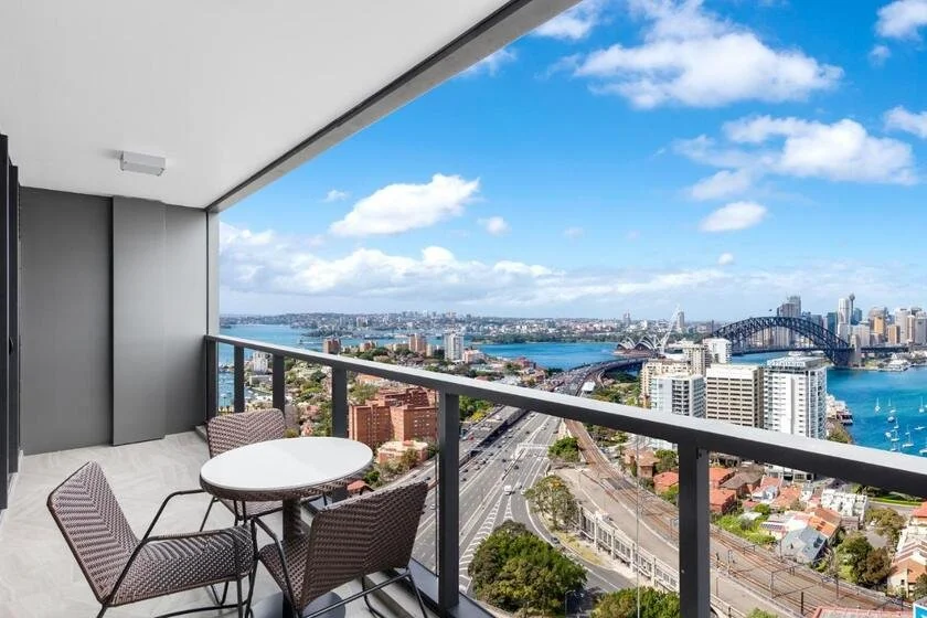 Meriton Suites North Sydney balcony with panoramic view of Sydney Harbour, Opera House, and Harbour Bridge