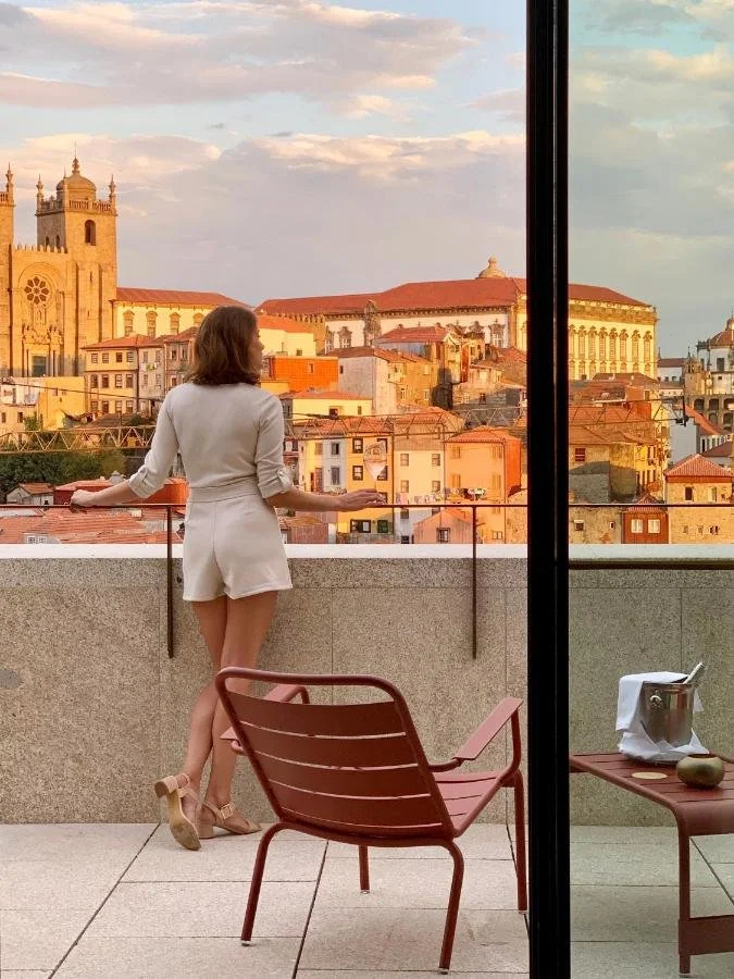 PortoBay Flores Porto hotel terrace at golden hour with view of Porto Cathedral and historic city rooftops