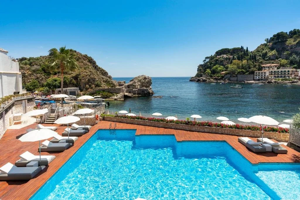 Mazzarò Sea Palace Taormina pool terrace with two rocky headlands framing Mazzarò Bay