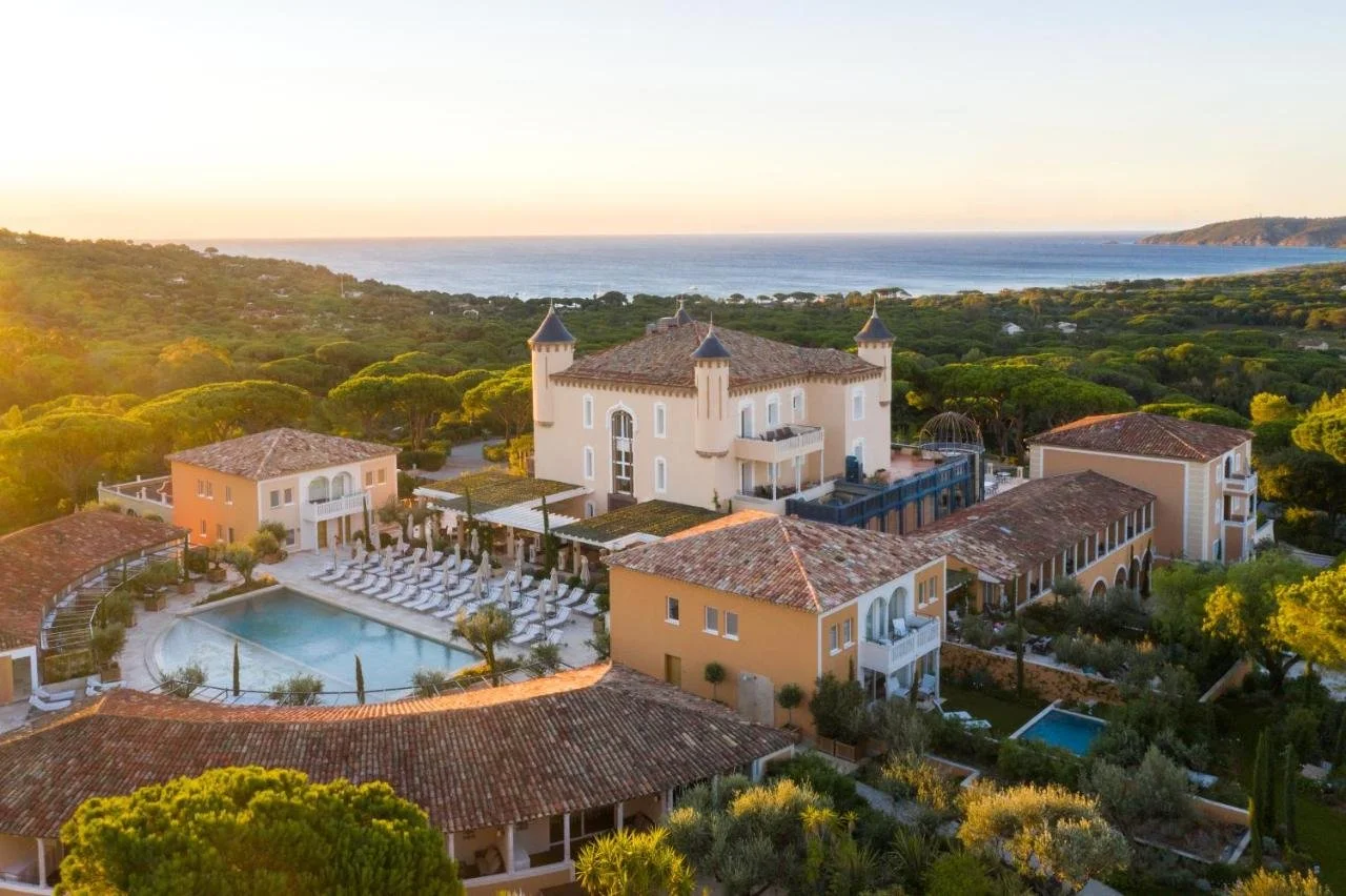 Airelles Château de la Messardière Saint-Tropez aerial view at golden hour with castle towers pool and Mediterranean sea