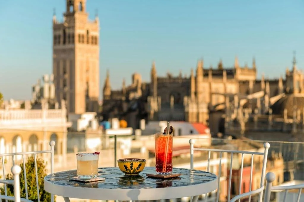 Querencia de Sevilla Autograph Collection Seville rooftop terrace with cocktails and La Giralda tower and Cathedral in the background