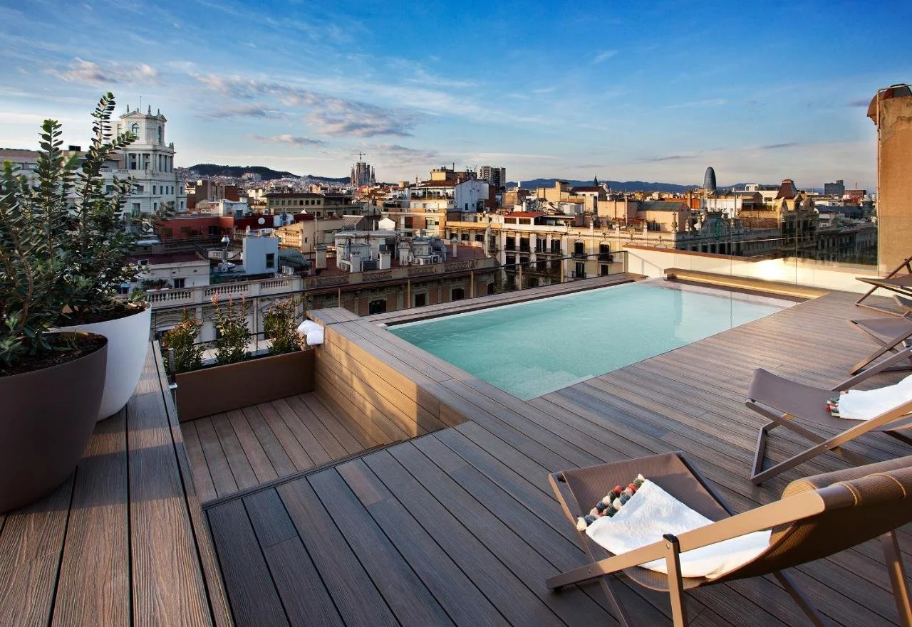 Vincci Gala Barcelona rooftop pool deck with sun loungers city panorama Sagrada Família spires on the left and Torre Glòries on the right