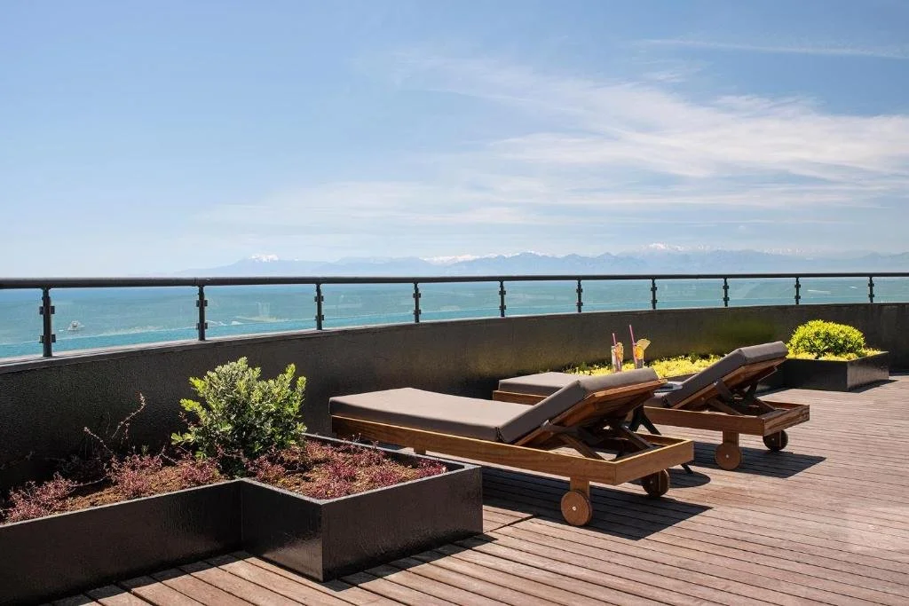 Voyage Belek Golf Spa Antalya rooftop sun deck with two loungers overlooking the Mediterranean Sea and snow-capped Taurus Mountains