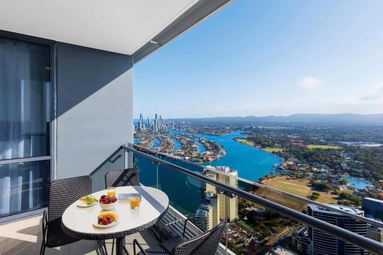 Meriton Suites Southport Gold Coast high-floor balcony with breakfast table overlooking the Broadwater waterways and Surfers Paradise skyline