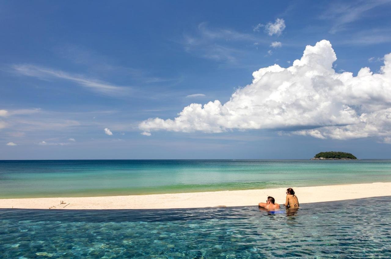 The Shore At Katathani Phuket infinity pool edge at Kata Noi Beach with turquoise Andaman Sea and offshore island