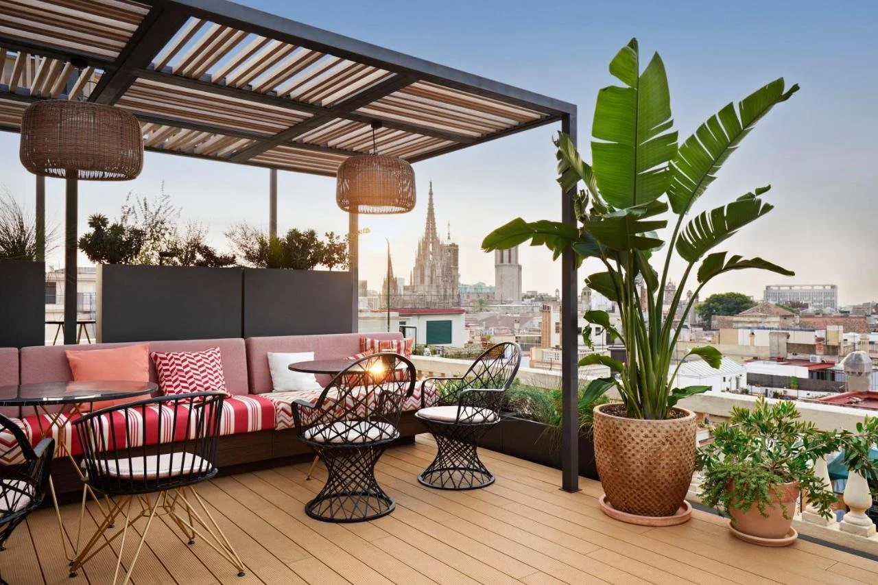Kimpton Vividora Hotel Barcelona Terraza de Vivi rooftop with Cathedral of Barcelona Gothic spires at sunrise and tropical plants