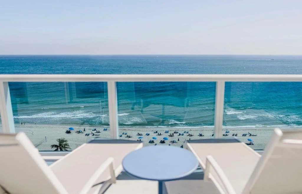 Hotel Maren Fort Lauderdale Beach high-floor balcony view over Fort Lauderdale beach with Atlantic Ocean and blue umbrellas below