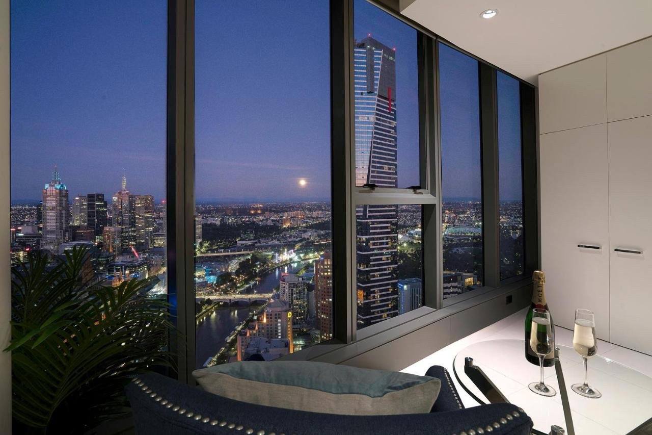 Platinum Luxury Stays at Freshwater Place Melbourne apartment at night with Eureka Tower in foreground and Yarra River and CBD skyline beyond