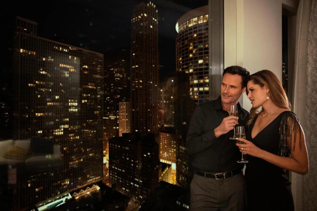 Sofitel Chicago Magnificent Mile couple enjoying Chicago skyline view from hotel room at night