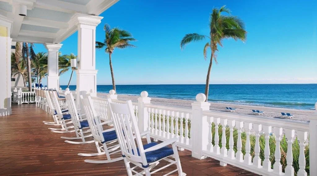 Pelican Grand Beach Resort Fort Lauderdale oceanfront veranda with white rocking chairs and direct Atlantic Ocean view