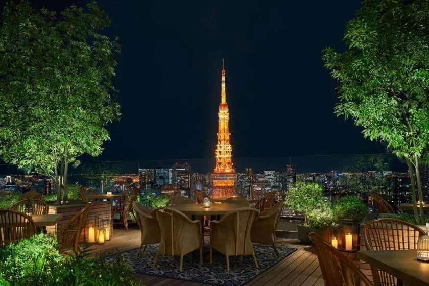 The Tokyo EDITION Toranomon rooftop terrace at night with Tokyo Tower