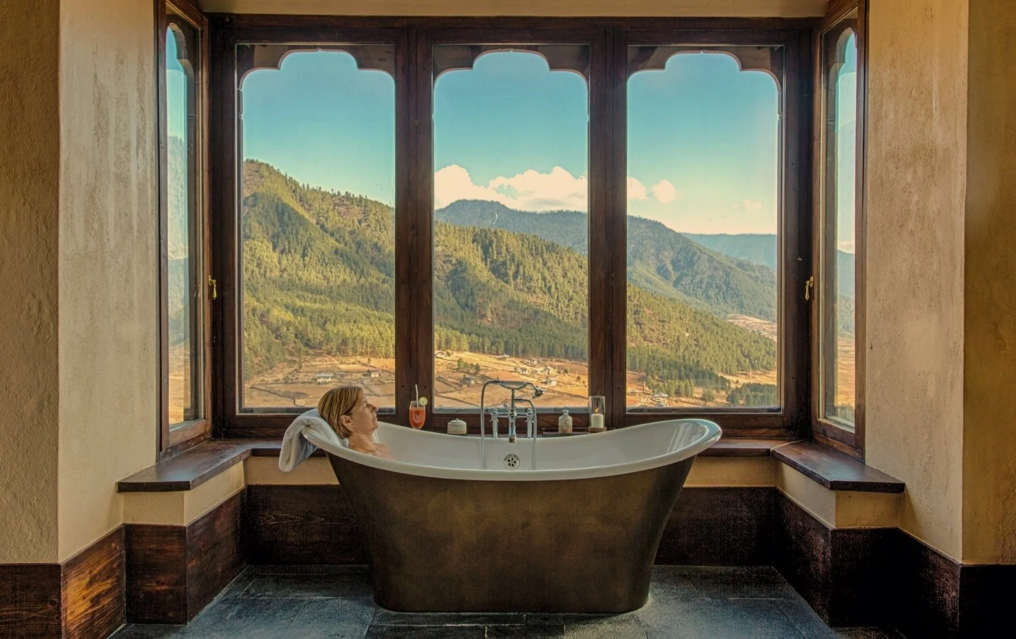 Woman takes a bath with a panoramic mountain view - Gangtey Lodge, Gangtey Valley, Buthan