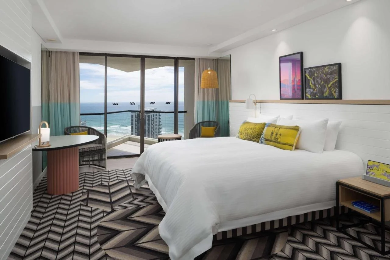 QT Gold Coast Surfers Paradise hotel room with bold geometric carpet and balcony facing the Pacific Ocean and beach