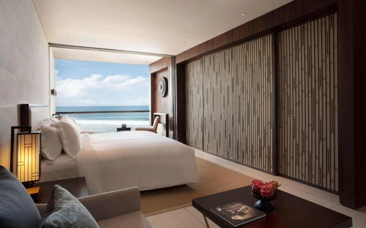 Alila Seminyak Bali ocean-view room with floor-to-ceiling windows and bamboo wall panels facing the Indian Ocean