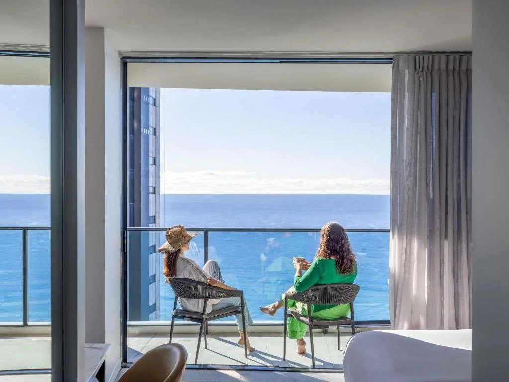 Peppers Broadbeach Gold Coast high-rise apartment balcony with two guests seated facing the Pacific Ocean horizon