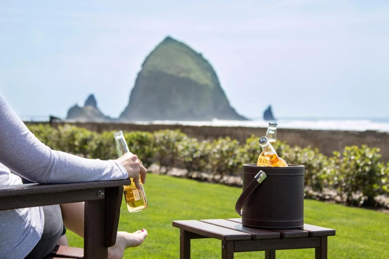 Surfsand Resort Cannon Beach woman enjoys a drink facing Haystack Rock