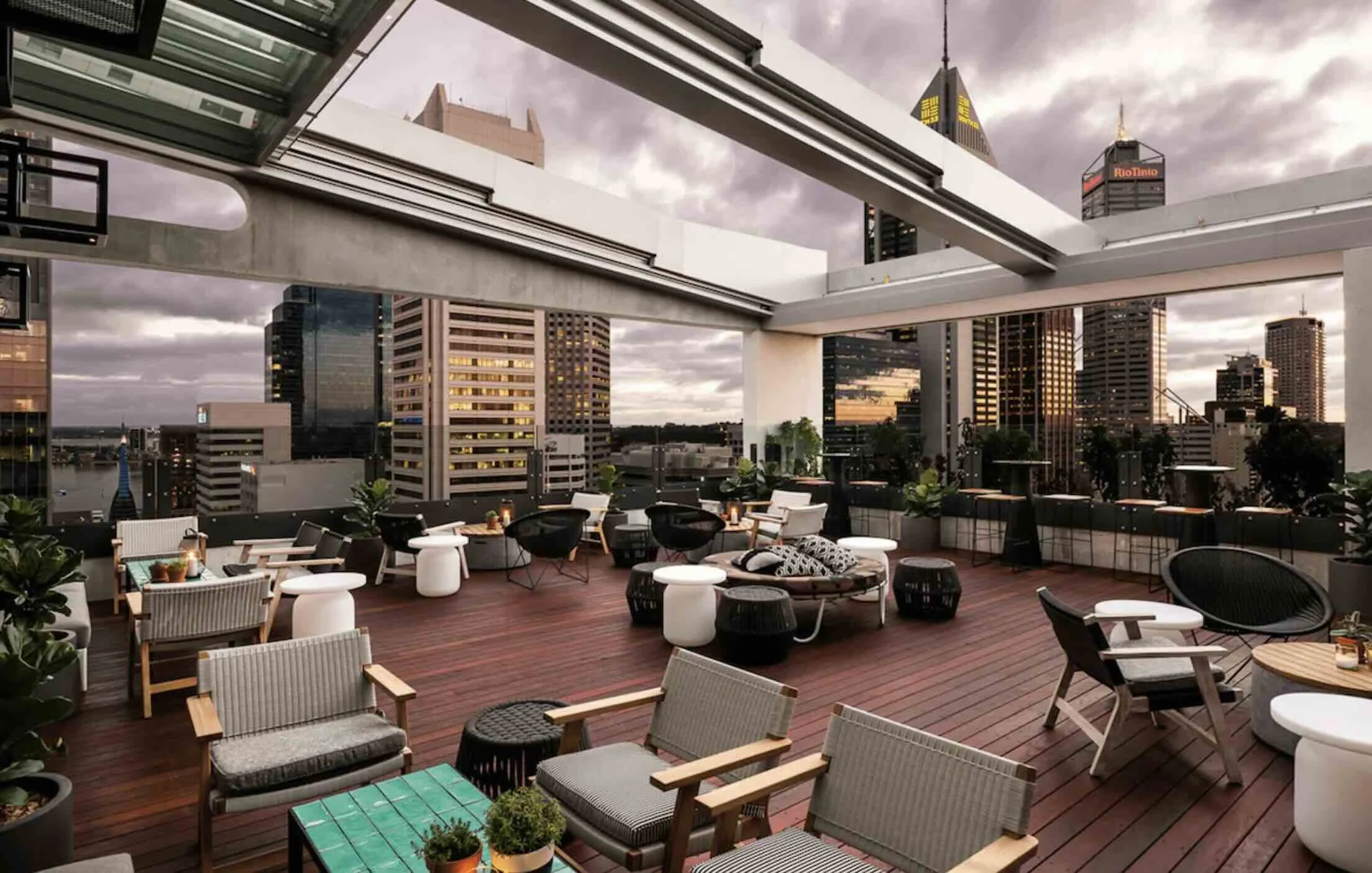 QT Perth rooftop bar terrace at dusk with Perth CBD skyline and glimpse of Swan River