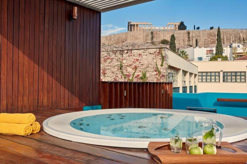 Herodion Hotel Athens rooftop terrace with round jacuzzi on wooden deck and close-up Acropolis and Parthenon colonnade view