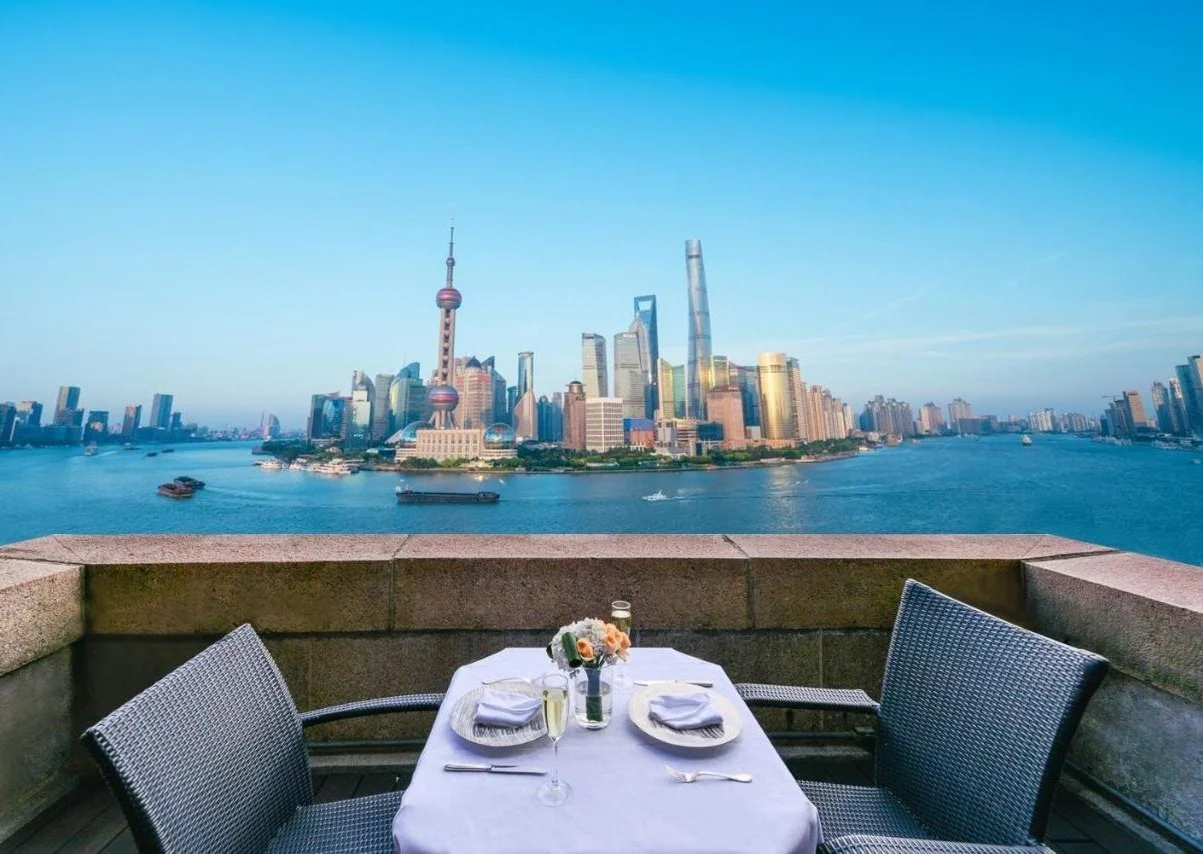 Fairmont Peace Hotel on the Bund outdoor terrace dining table overlooking the Huangpu River and full Pudong skyline with Oriental Pearl Tower