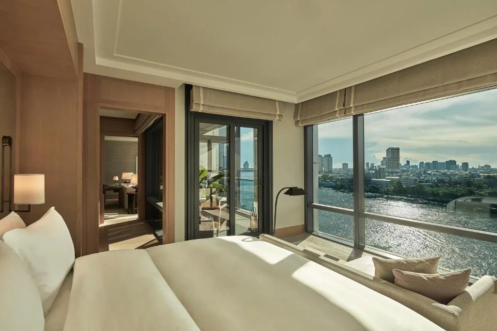 Capella Bangkok suite with floor-to-ceiling windows and Chao Phraya River view and Bangkok skyline beyond