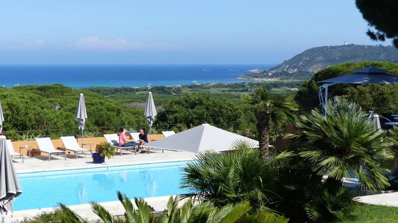 Hôtel Les Bouis Ramatuelle room interior with wicker pendant lamp and balcony overlooking pine tree garden