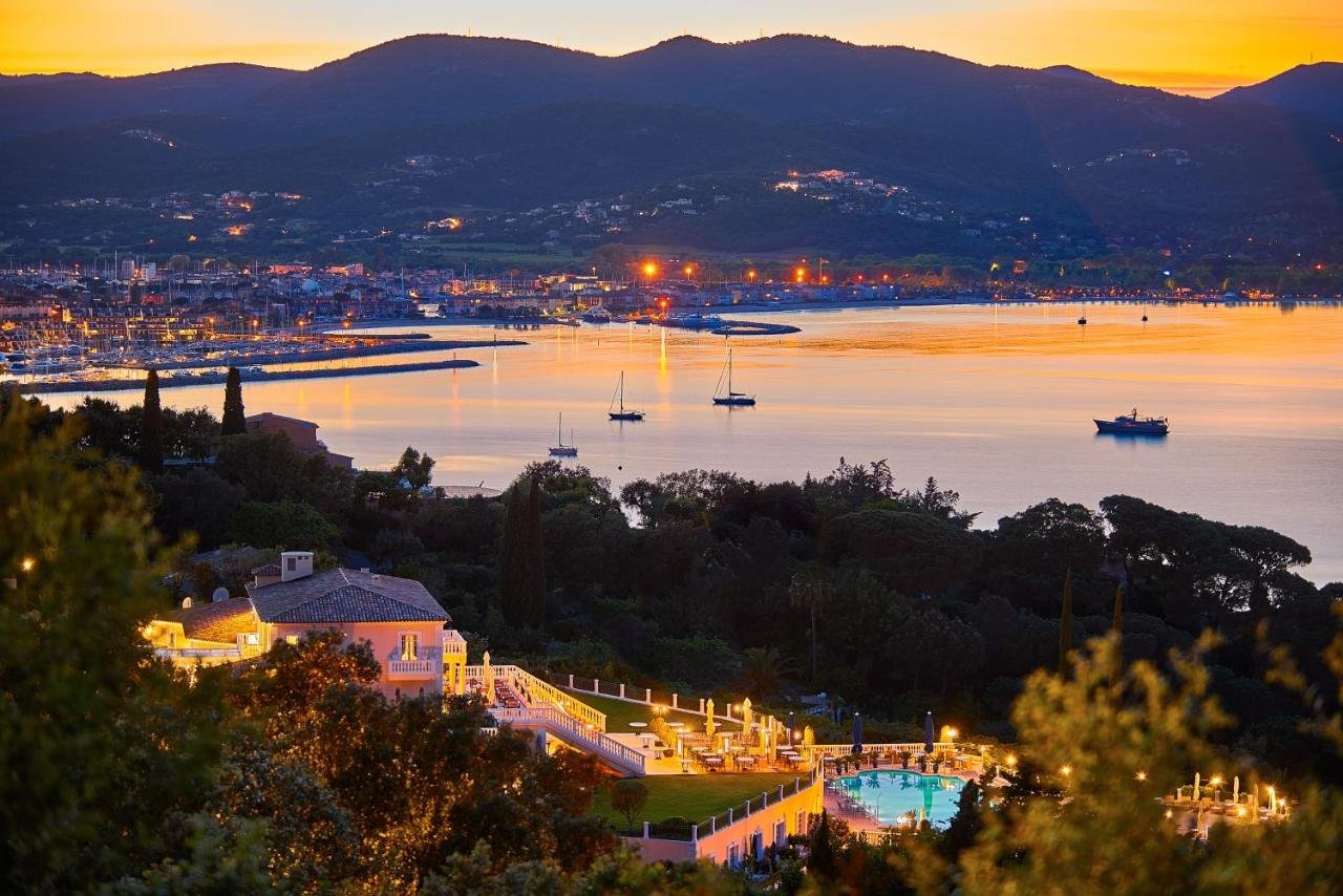 Althoff Villa Belrose Saint-Tropez panoramic view at dusk of the Gulf of Saint-Tropez with marina lights and sailboats