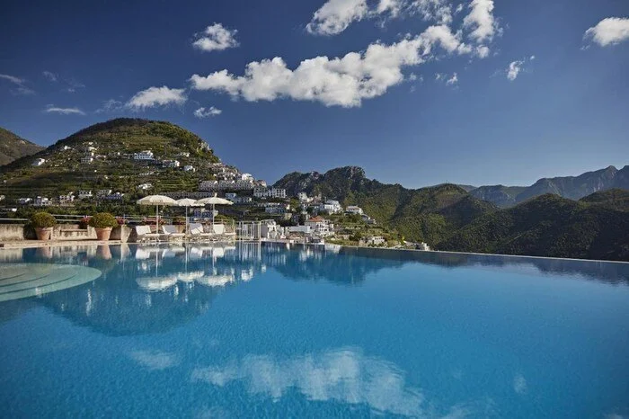 Caruso Belmond heated infinity pool reflecting the Ravello mountains and valley of the Amalfi Coast