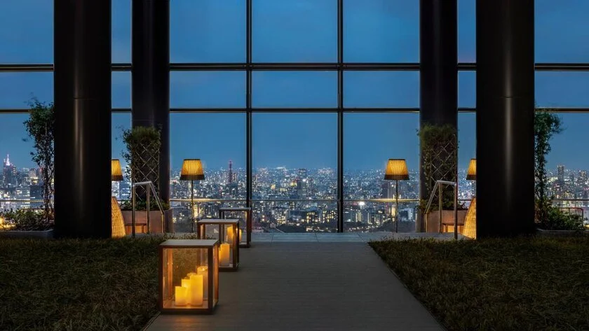 Bulgari Hotel Tokyo indoor terrace with floor-to-ceiling windows framing Tokyo skyline at night
