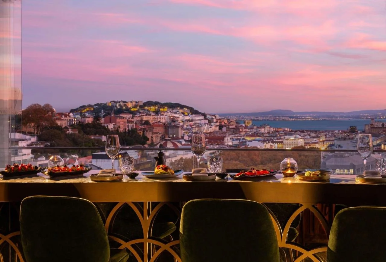 Tivoli Avenida Liberdade Lisboa Sky Bar by Seen rooftop restaurant dining table at dusk with illuminated São Jorge Castle and Tagus River panorama