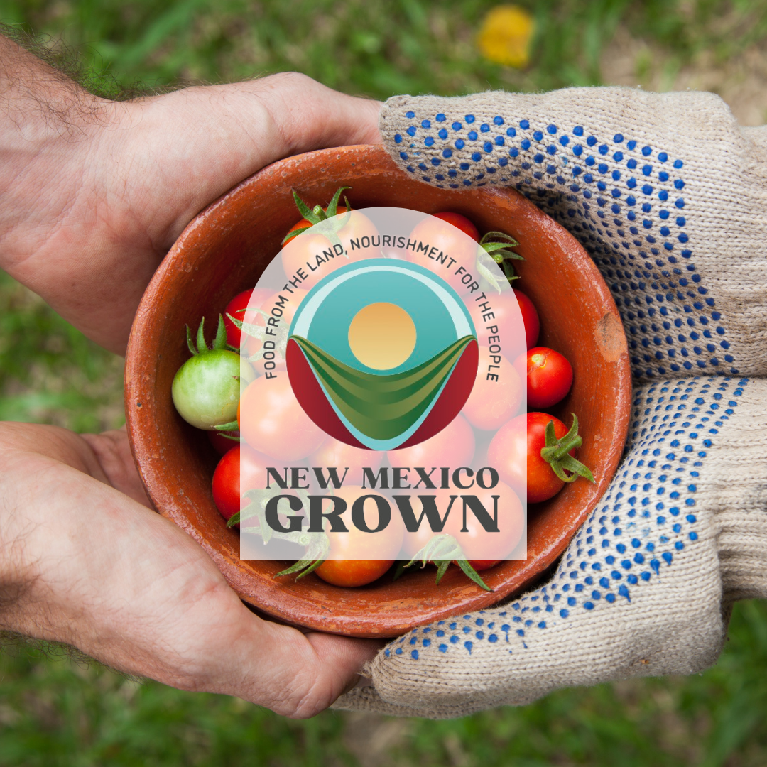 Image of a pair of hands passing a bowl of freshly picked tomatoes to another pair of hands with the New Mexico Grown logo over it which reads "Food from the land, nourishment for the people. New Mexico Grown".
