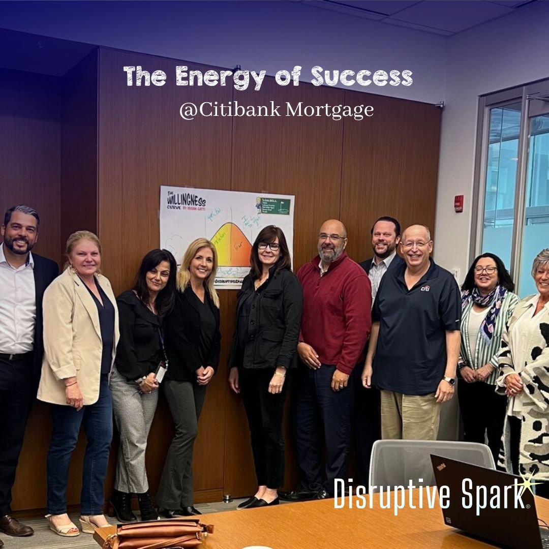 Group of ten professionals standing in a conference room with a whiteboard behind them, displaying a diagram titled 'The Willingness Curve.' The photo has the words 'The Energy of Success' and '@Citibank Mortgage' written on it, and the bottom right 