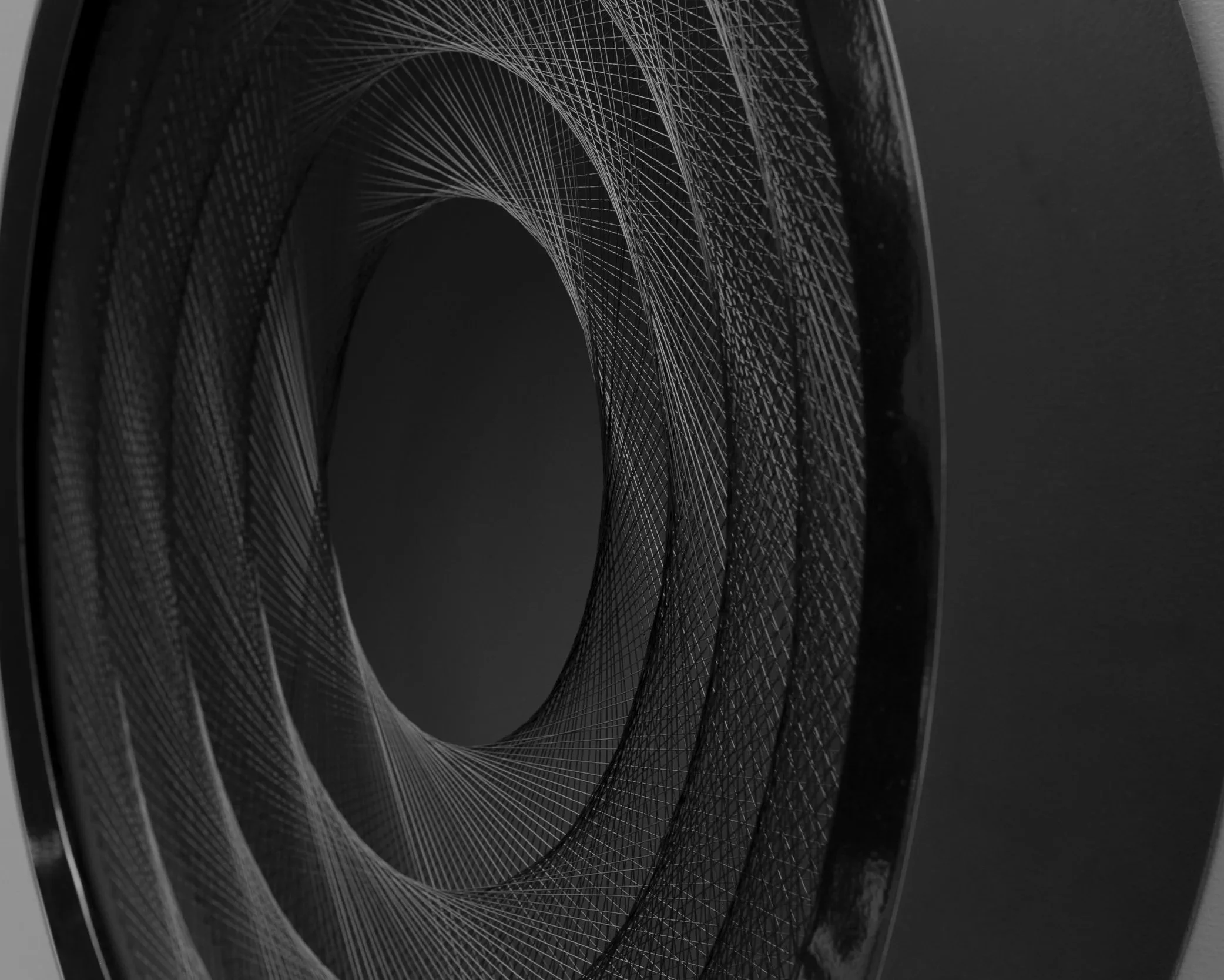 Close-up of a metallic, geometrically intricate, futuristic sculpture or art piece with circular, wireframe pattern.