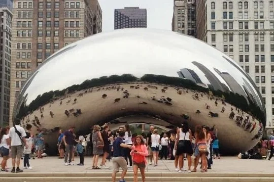 The Cloud Gate sculpture at Millennium Park in Chicago with people taking photos around it.
