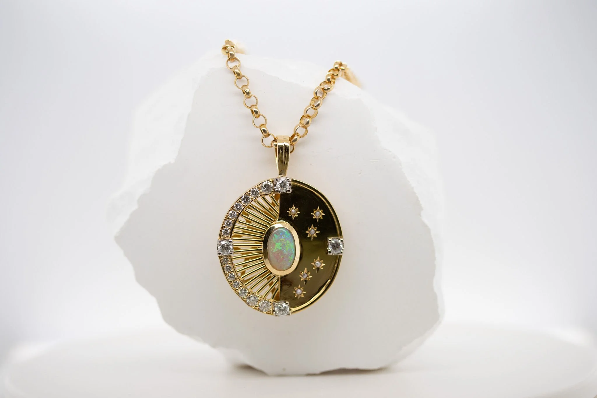 This handcrafted 18ct compass pendant transformed this client's sentimental heirlooms into something entirely new but still personal and layered with meaning.

The opal centre sends rays of sunshine into diamond sparkles on one side, and a night sky 