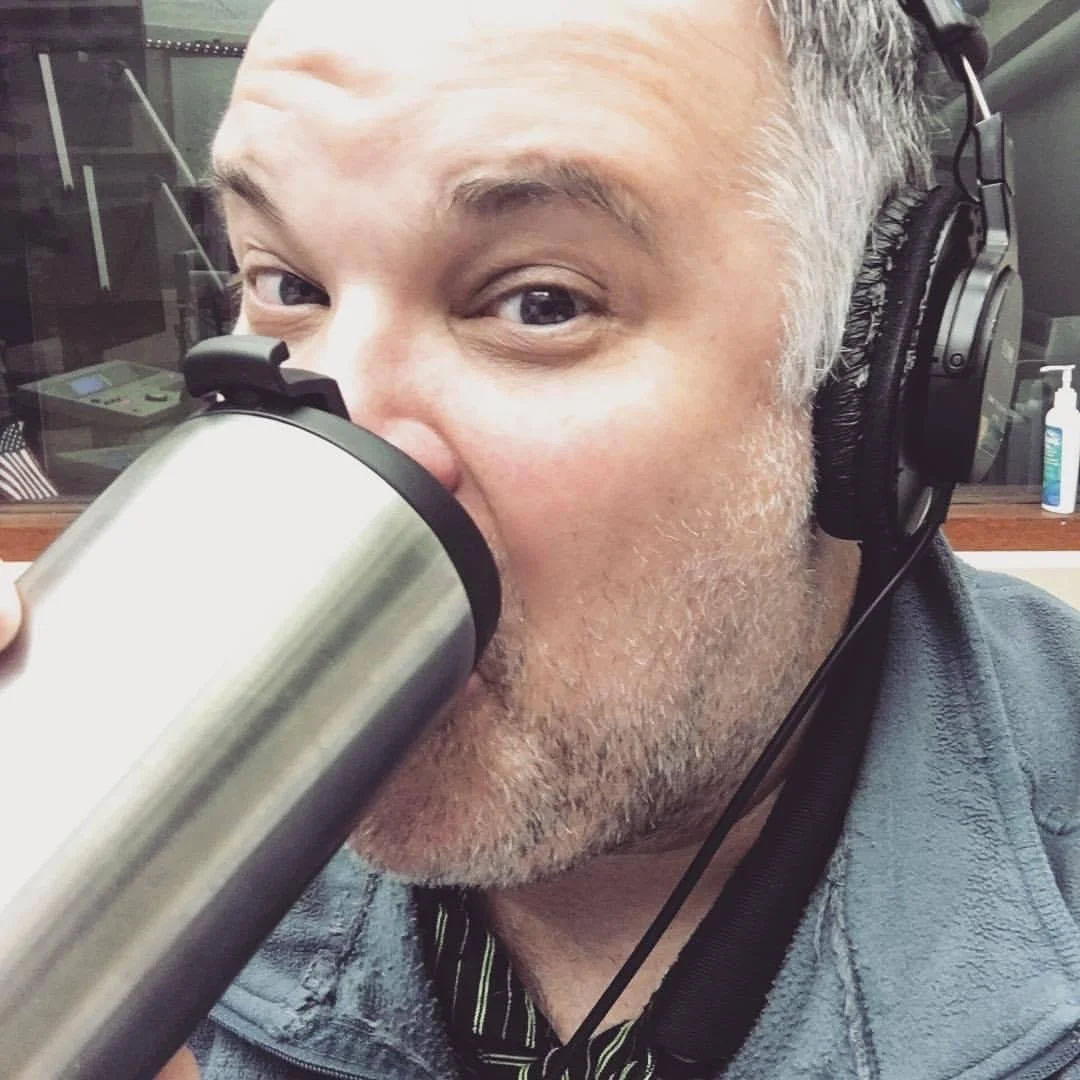 Guy Dye wearing headphones and coffee.