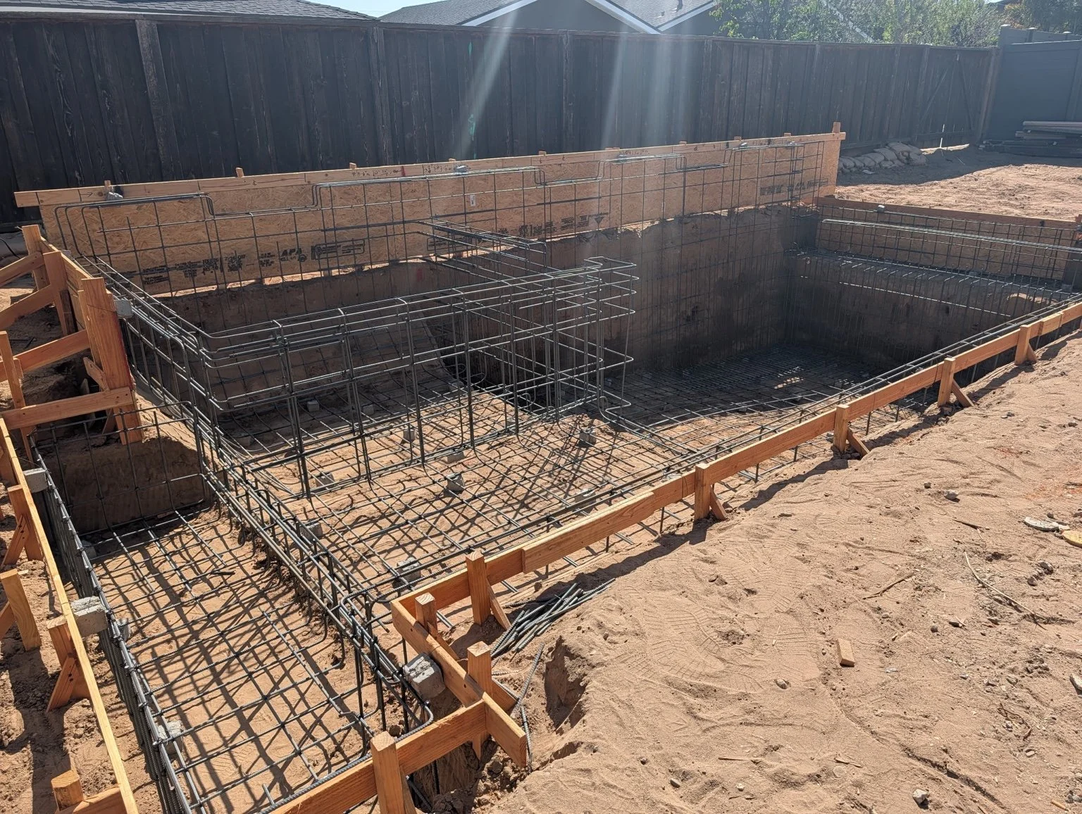 Engineered steel reinforcement for a custom swimming pool and spa under construction