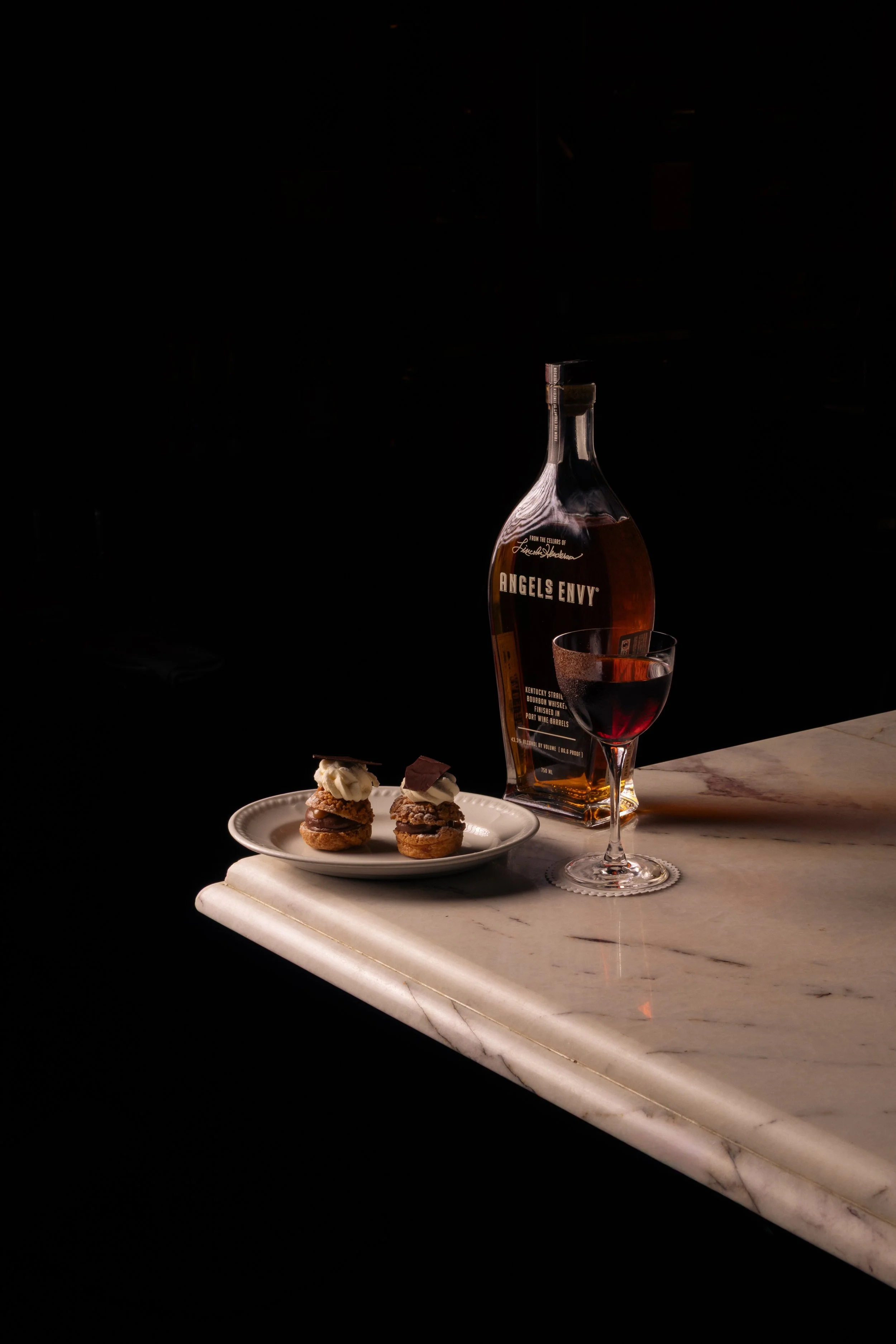 Two profiteroles and an Angel's Envy cocktail at Prahran steakhouse Angus & Bon.