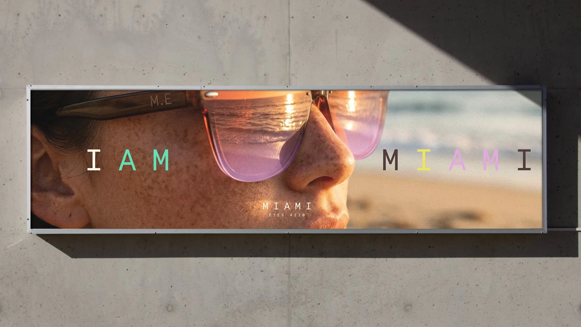 A promotional billboard showing a close-up profile of a person wearing sunglasses with a reflection of a sunset on the lenses. The word 'MIAMI' is creatively spelled out across the image with colorful letters, and the text 'MIAMI EYES 4220' is at the bottom.