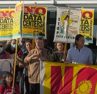 A group of protestors hold up signs saying "No Data Centers"